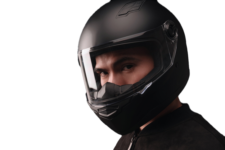 Person wearing a matte black motorcycle helmet with a clear visor, looking forward.