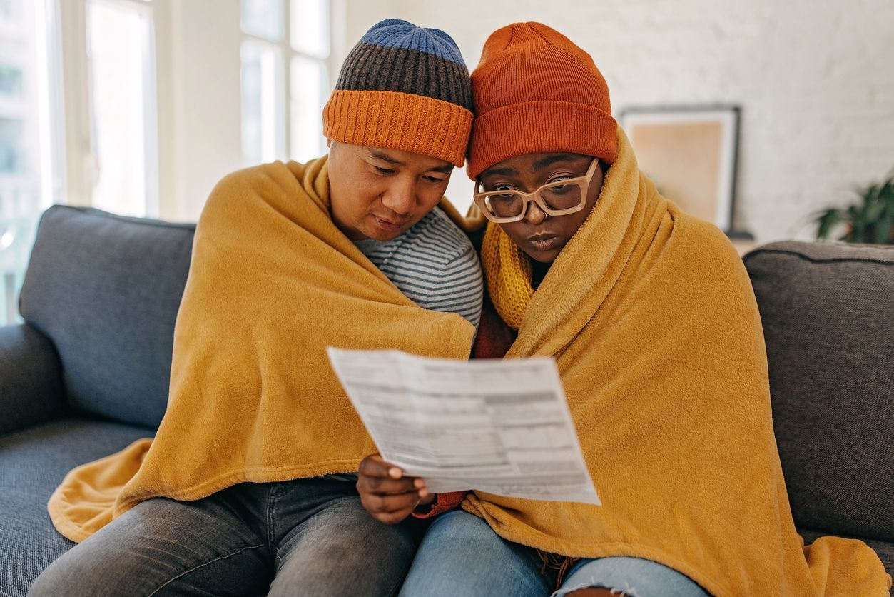 A couple looking at an HVAC bill for not replacing the furnace.