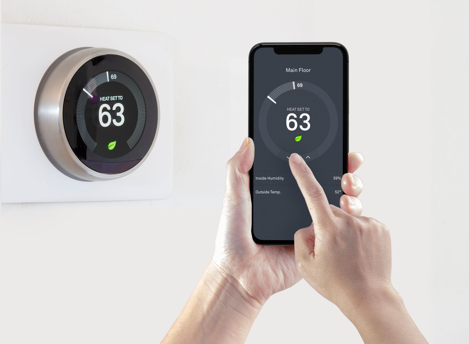 Homeowner using a smartphone to control a smart thermostat remotely.