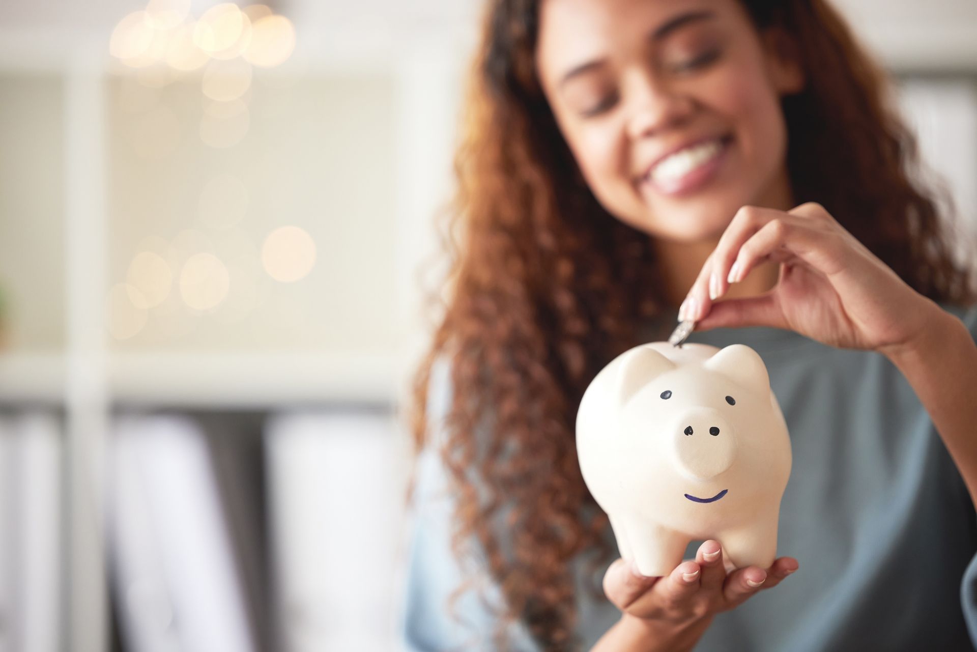 Granville homeowner with a piggy bank representing adjusting thermostat to save on summer AC costs.
