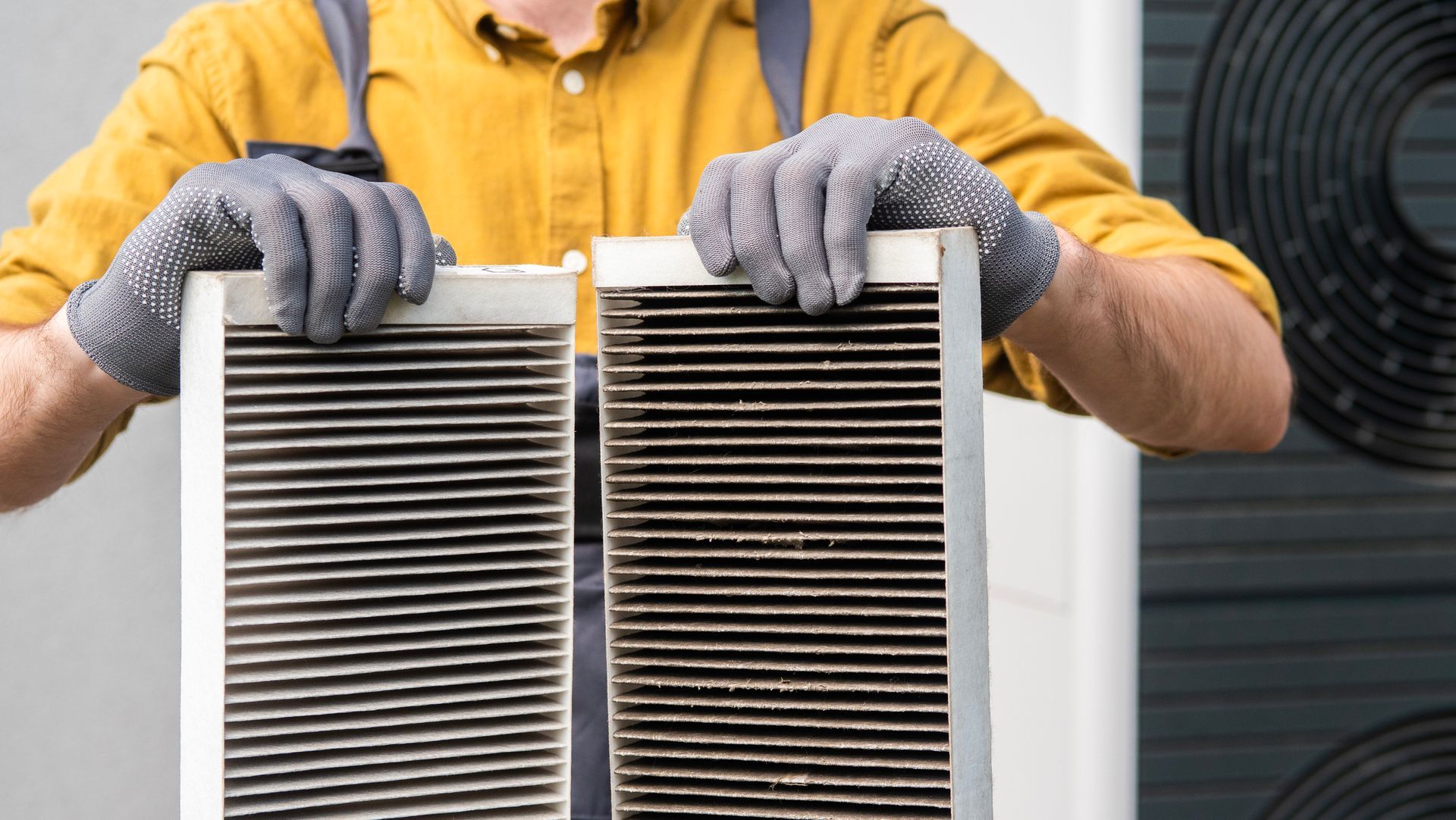 Mr. Air technician replacing a dirty AC air filter with a clean one in a residential HVAC system.