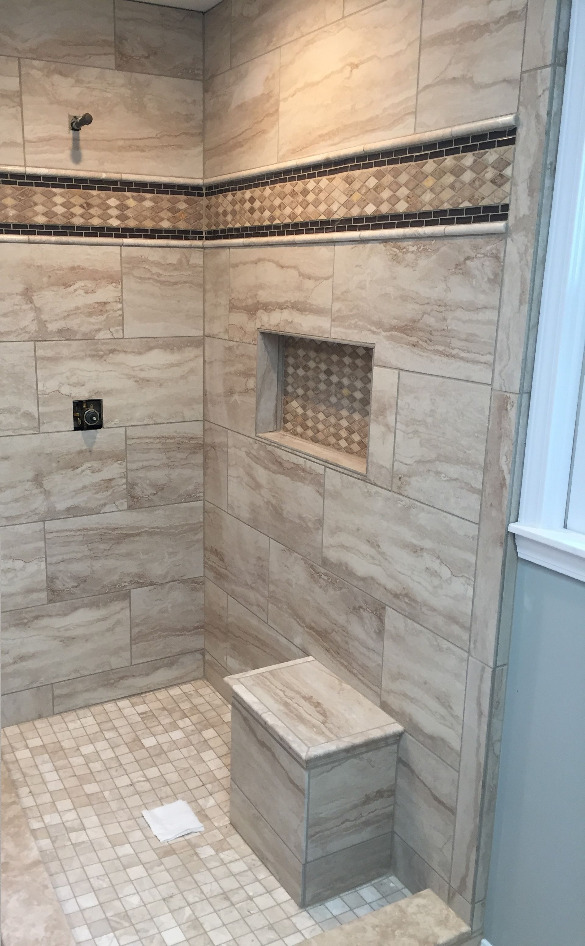 There is a shower head in the shower with water coming out of it.