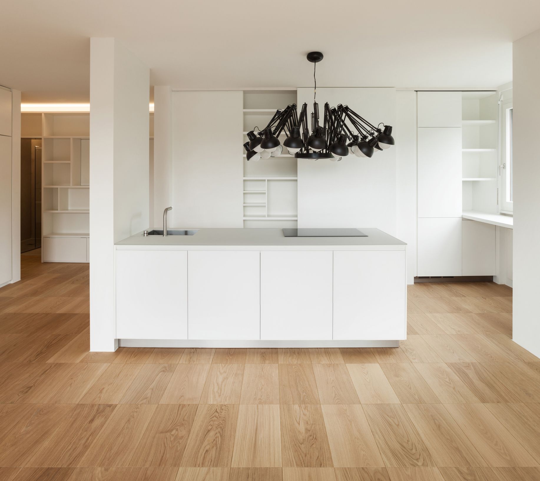 A kitchen with white cabinets and a chandelier hanging from the ceiling