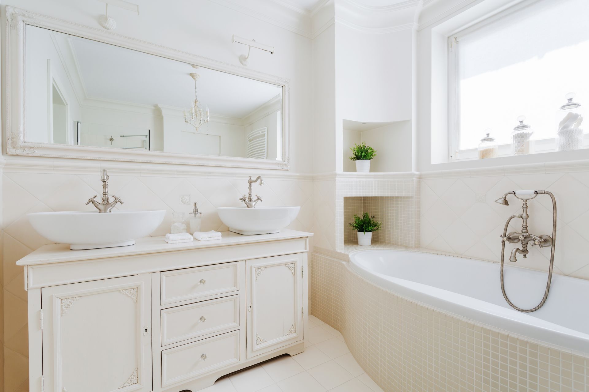 A bathroom with two sinks , a tub , a mirror and a window.