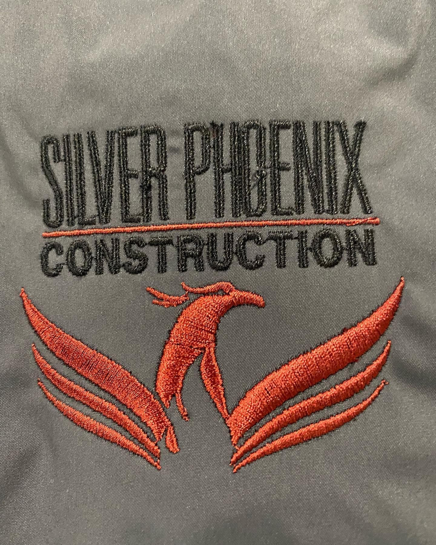 Logo for Silver Phoenix Construction: Orange phoenix bird below grey text on a light grey background.