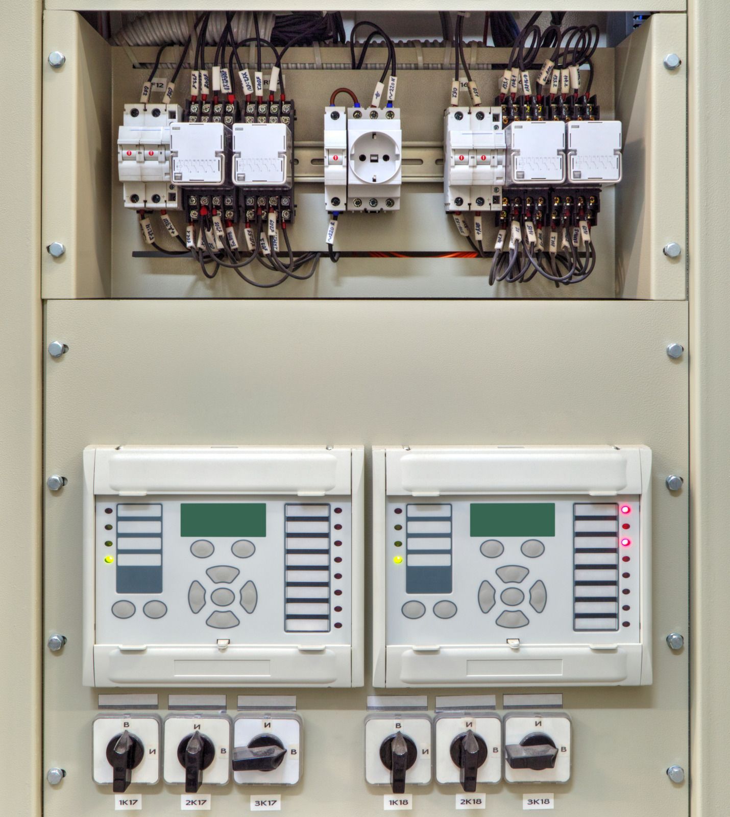 Exterior electrical boxes mounted on a beige building. Various sizes and shapes, gray and blue metal.