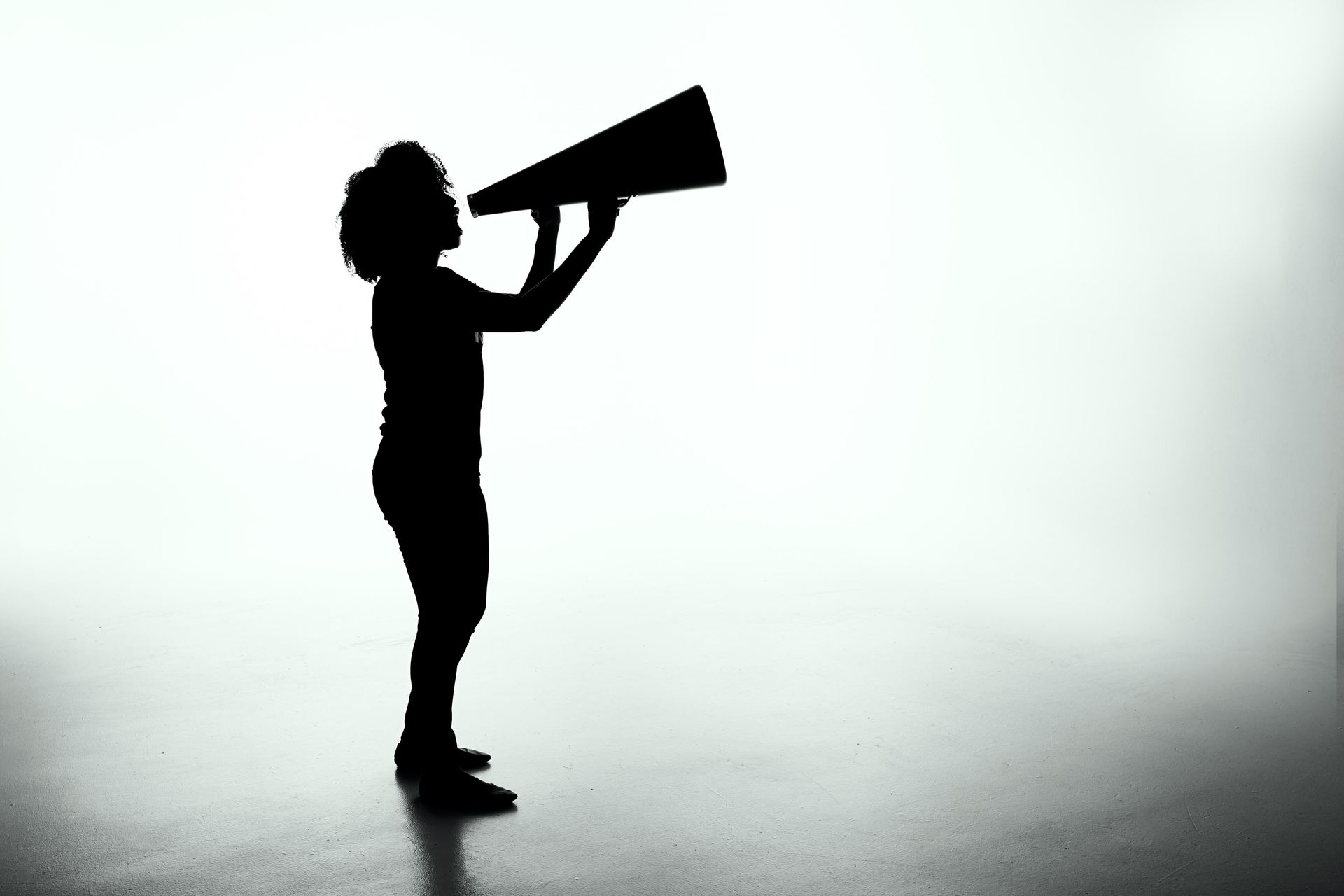 Woman with a megaphone held up to her mouth - sales psychology