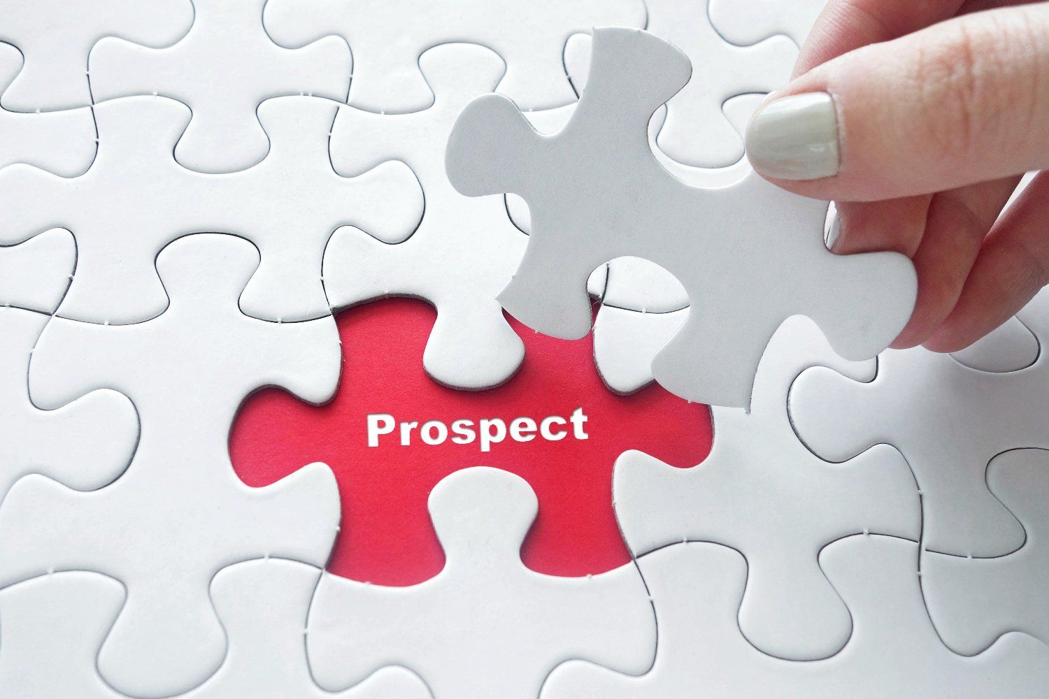 white jigsaw with one piece being placed with the word prospecting  in the jigsaw