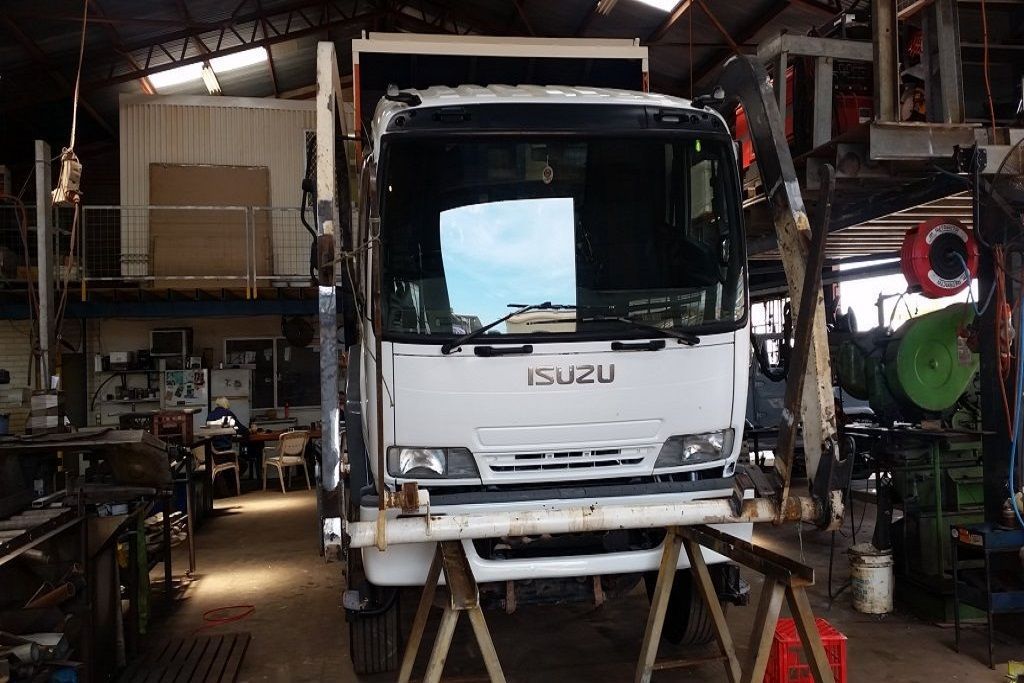 A White Isuzu Truck is Parked in a Garage