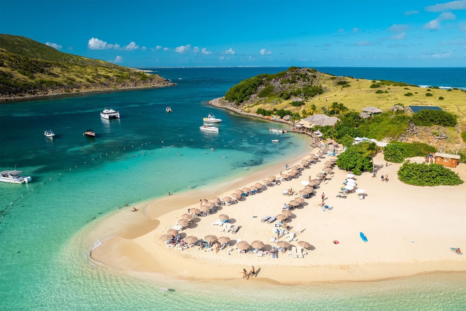 Karibuni beach restaurant on Pinel Island, St Martin, FWI. Beach chairs and umbrellas... by the clear water of the caribbean sea.