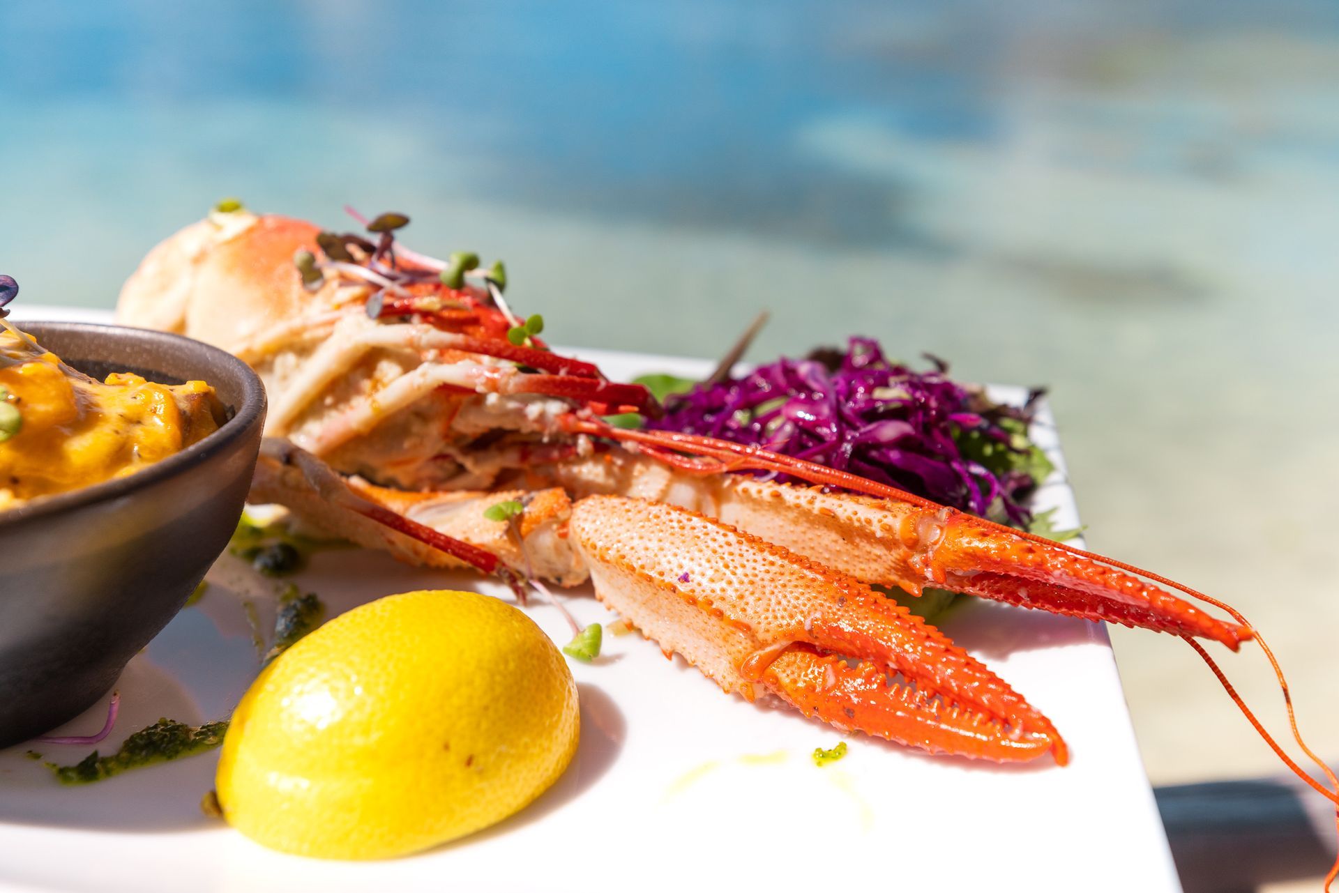 Grilled fresh lobster at the Karibuni Restaurant by the turquoise water of Pinel Island