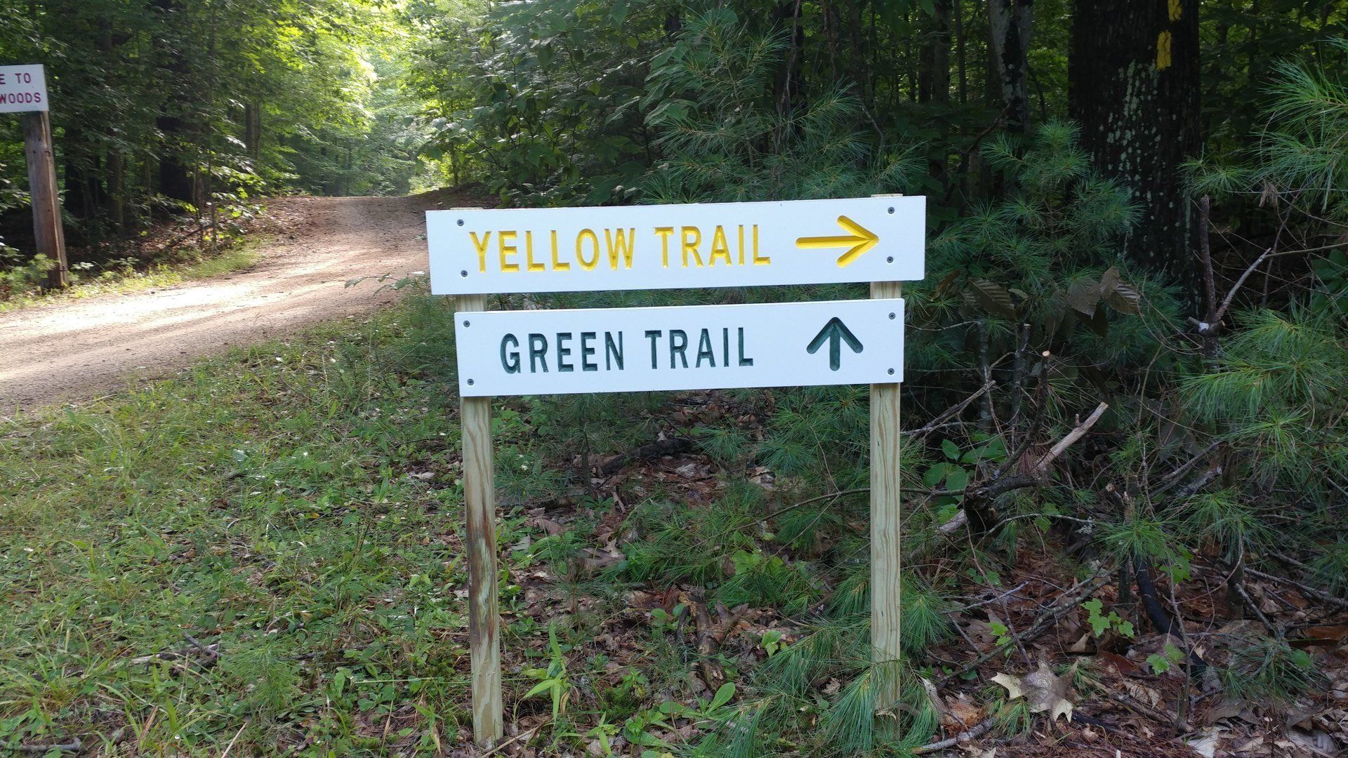 A sign that says yellow trail and green trail on it