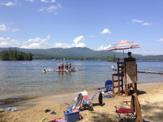 A beach with a lifeguard tower and people swimming in the water