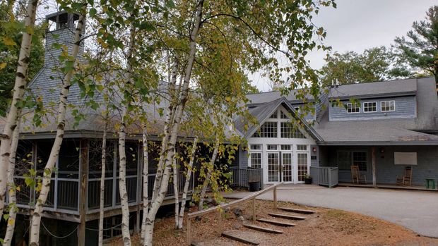 A large house with a lot of windows is surrounded by trees.