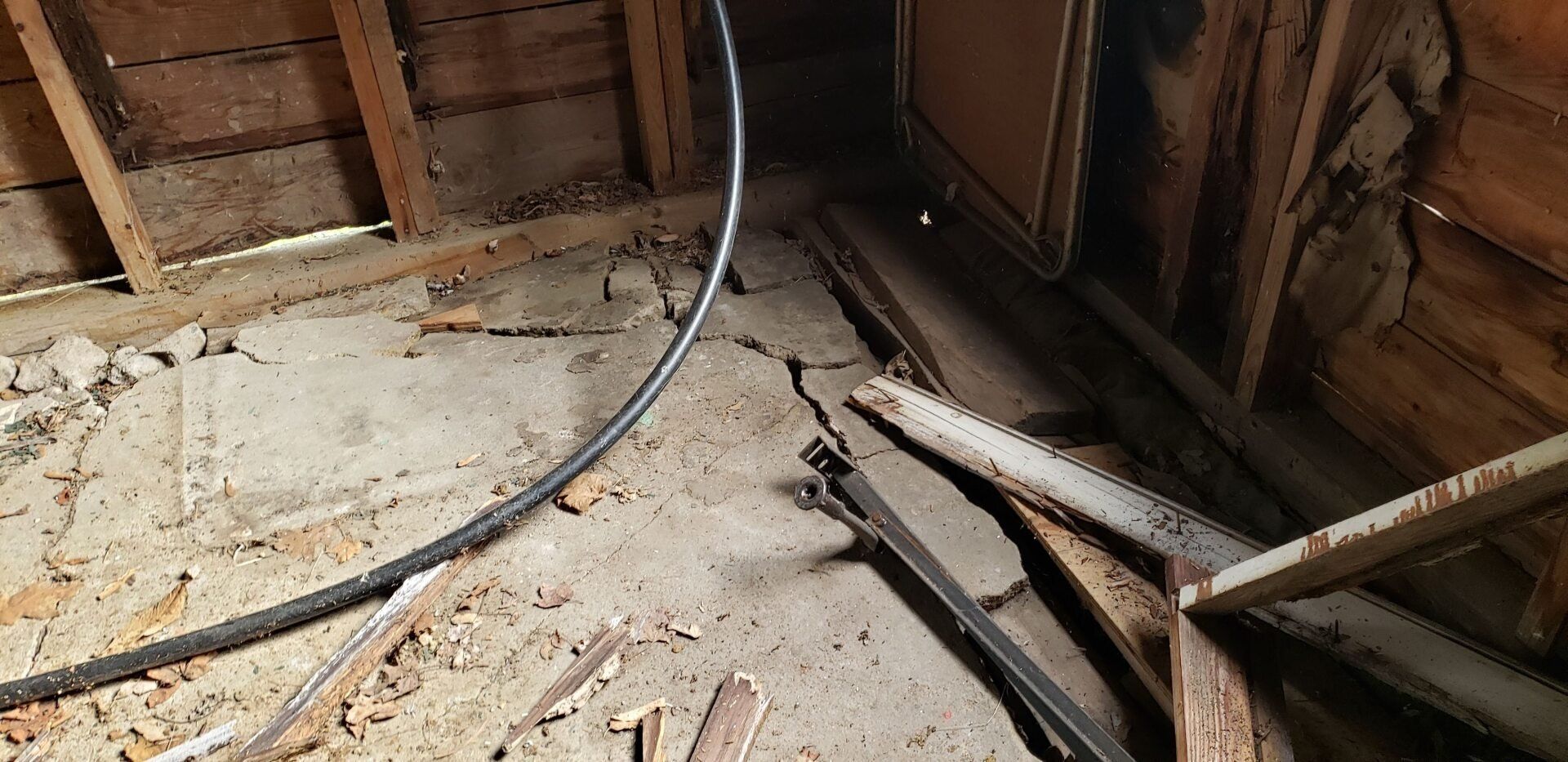 A room with a lot of wood and a lot of wires on the floor.