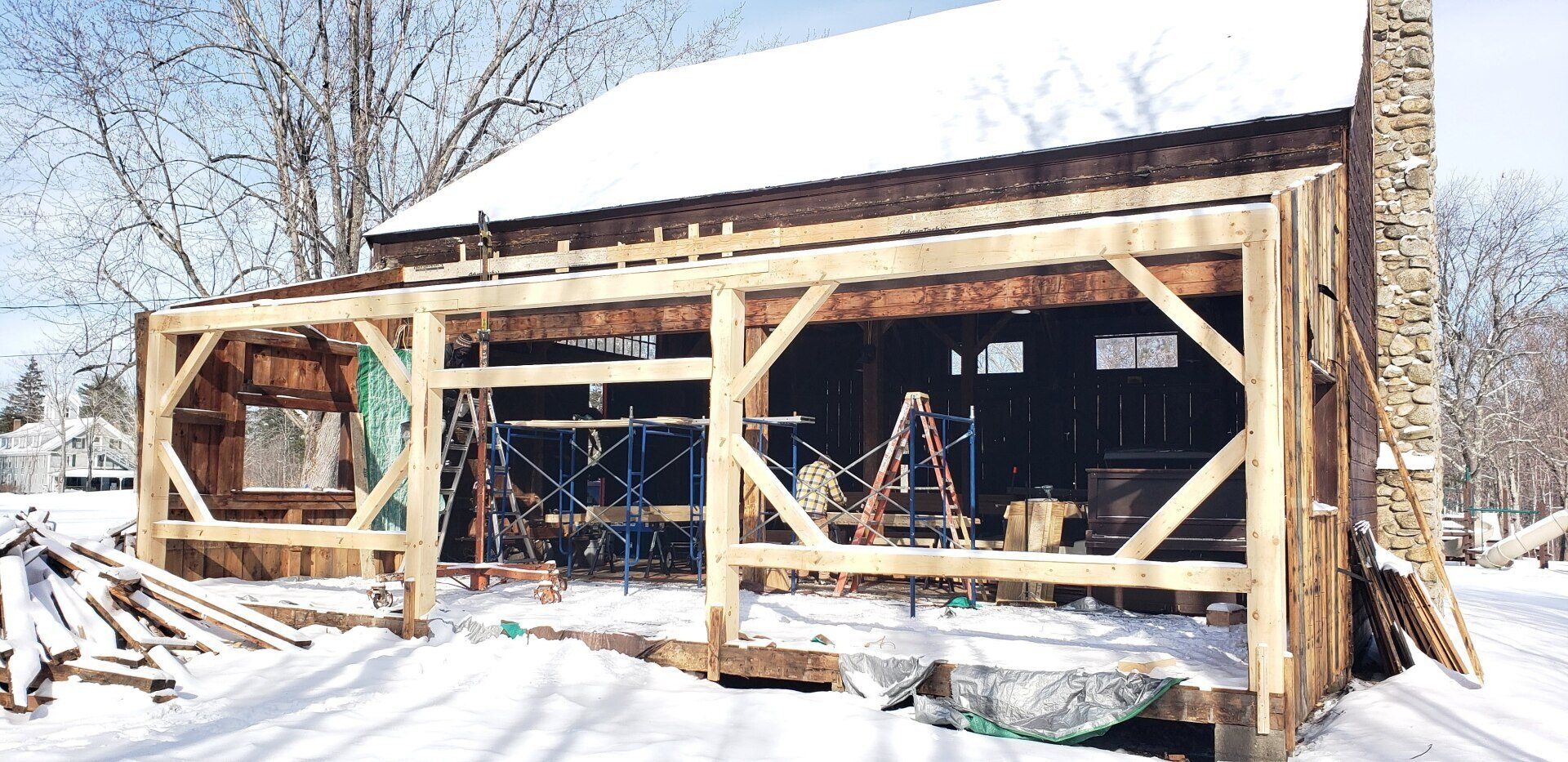 A wooden house is being built in the snow.