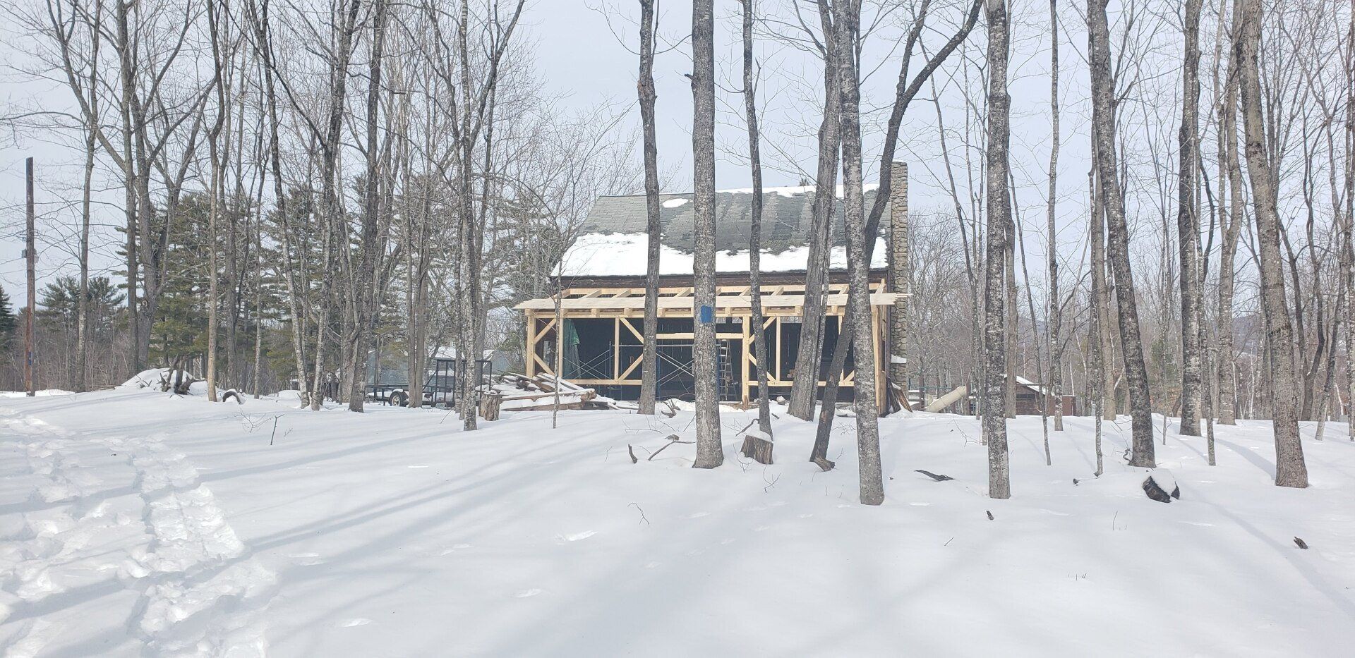 A house is being built in the middle of a snowy forest.