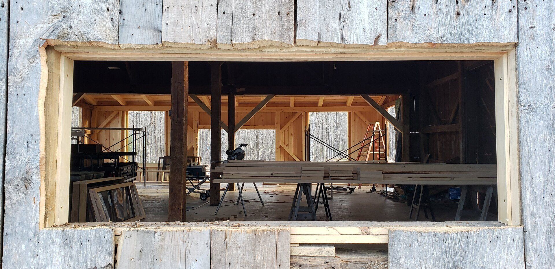 There is a large window in the wall of a building under construction.
