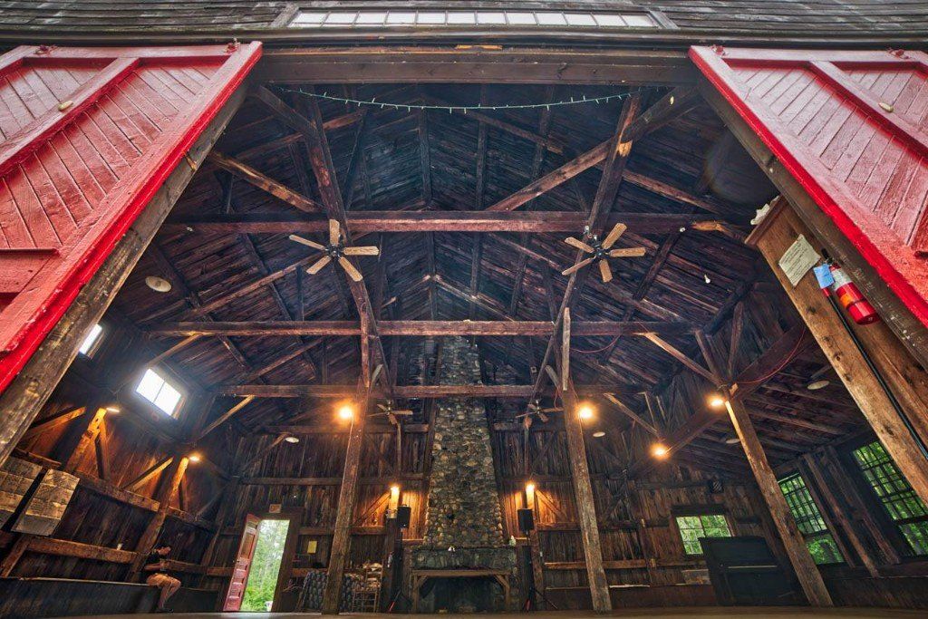 The inside of a barn with the doors open and a fireplace.