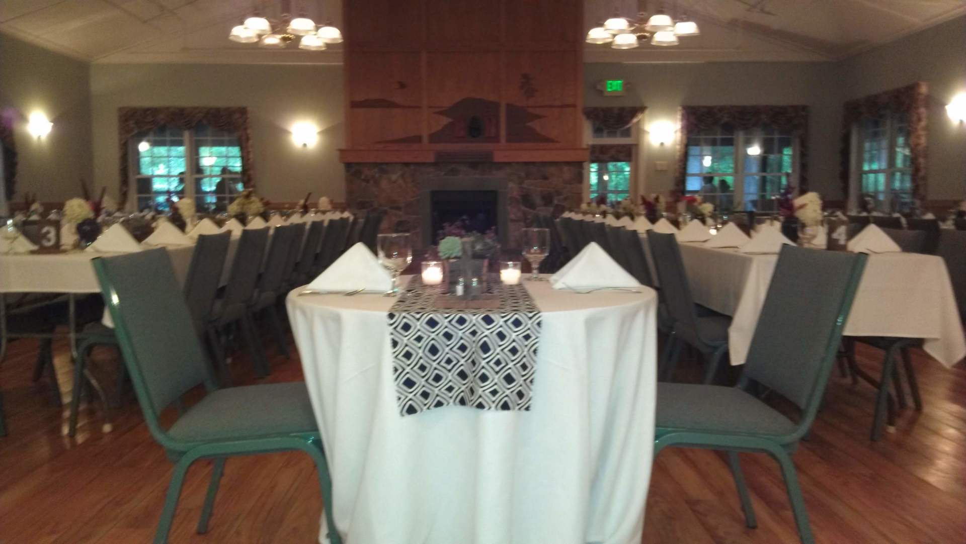 A large room with tables and chairs and a fireplace