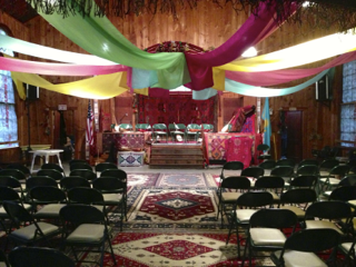 A room filled with chairs and colorful cloths hanging from the ceiling
