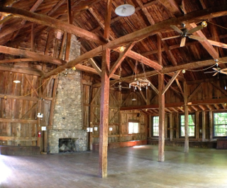 A large room with wooden beams and a fireplace
