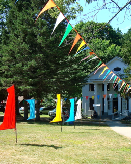 A row of colorful flags in front of a house