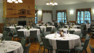 A large room with tables and chairs set up for a party