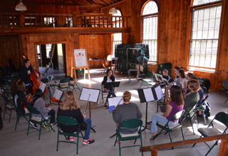 A group of people are sitting in a circle playing musical instruments