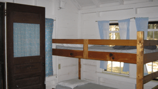 A bunk bed in a room with blue curtains