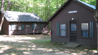 A couple of cabins in the woods one of which has the word lodge on it