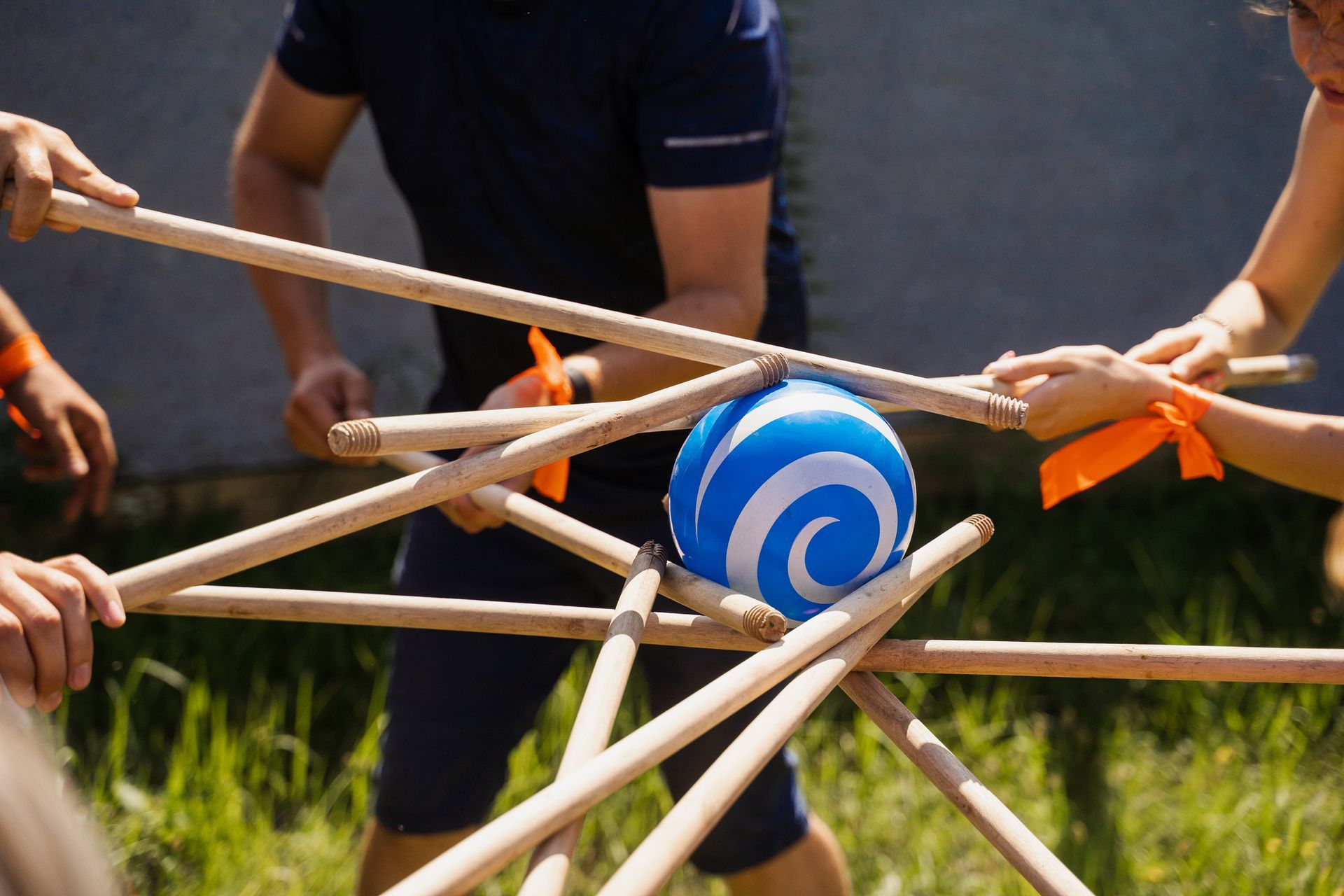 A group of people are playing a game with sticks and a ball.