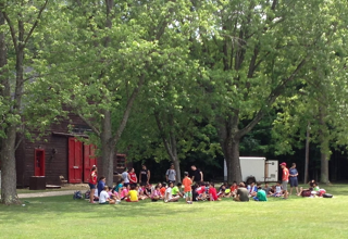 A group of people are sitting on the grass in a park.