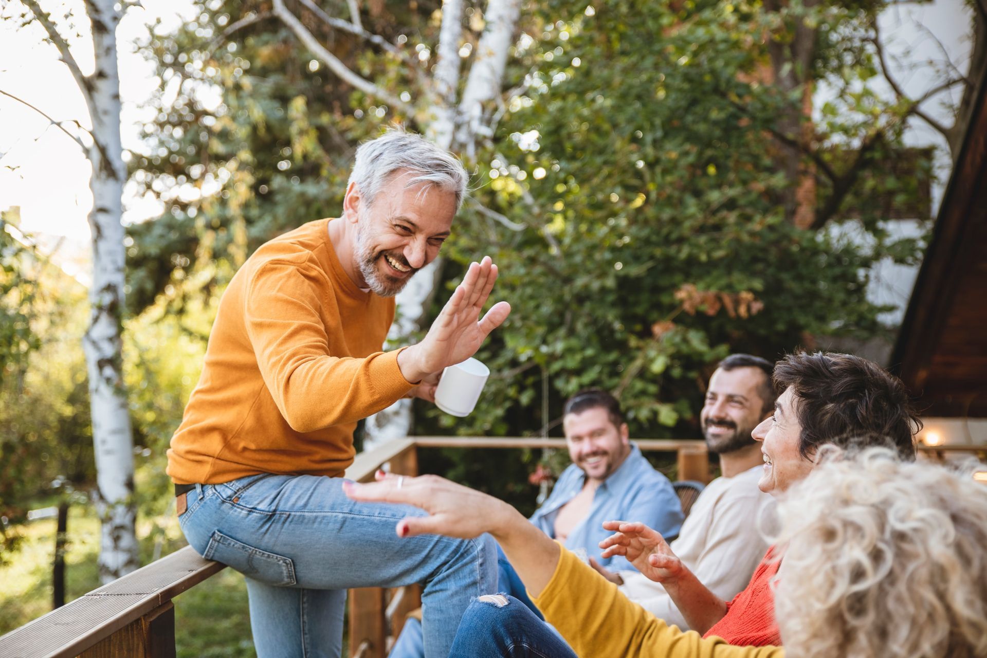 A group of people are sitting on a deck giving each other high fives.