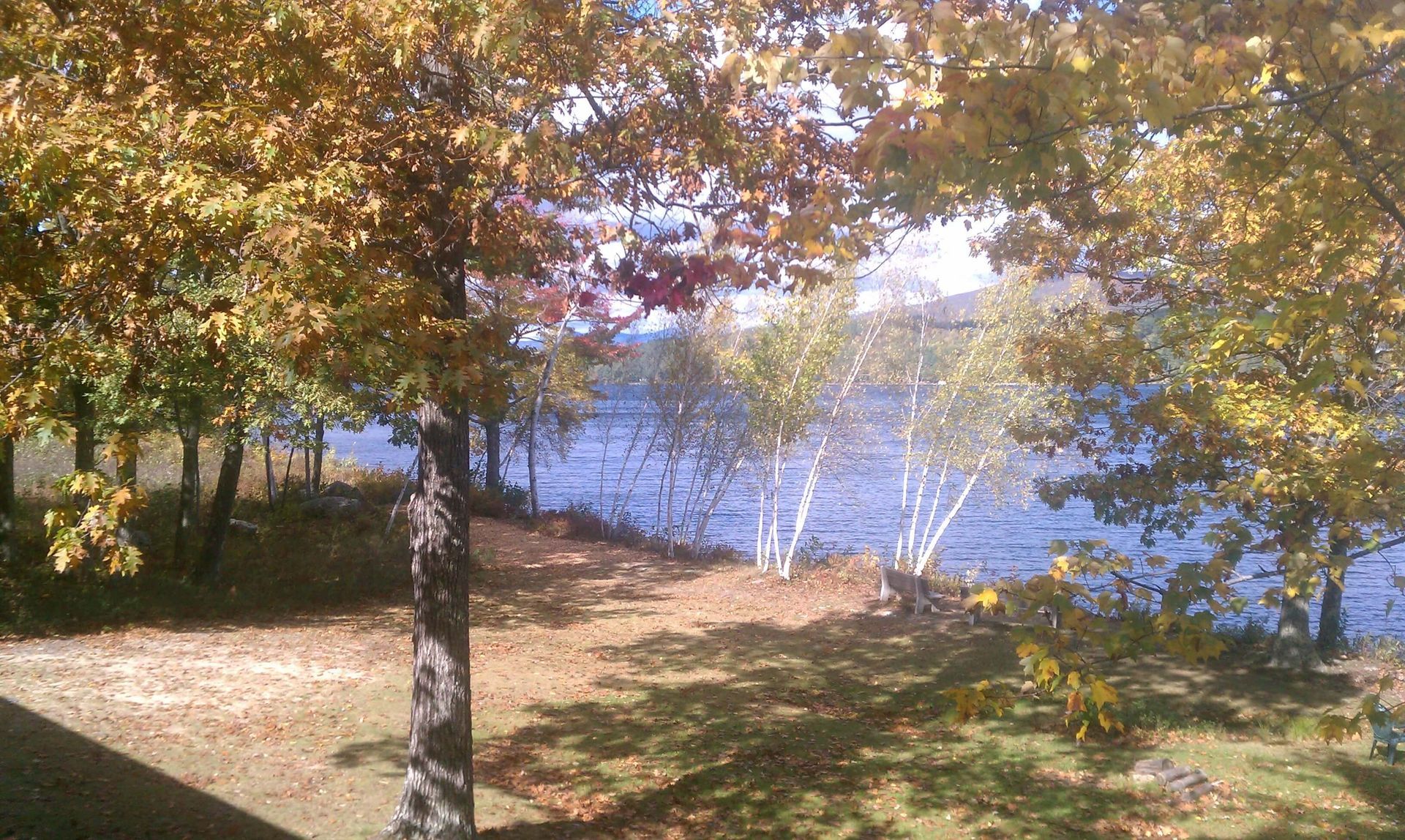 A lake with mountains in the background and the geneva point center logo