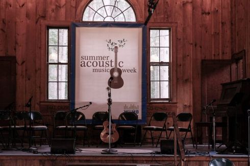 A stage with a sign that says summer acoustic music week