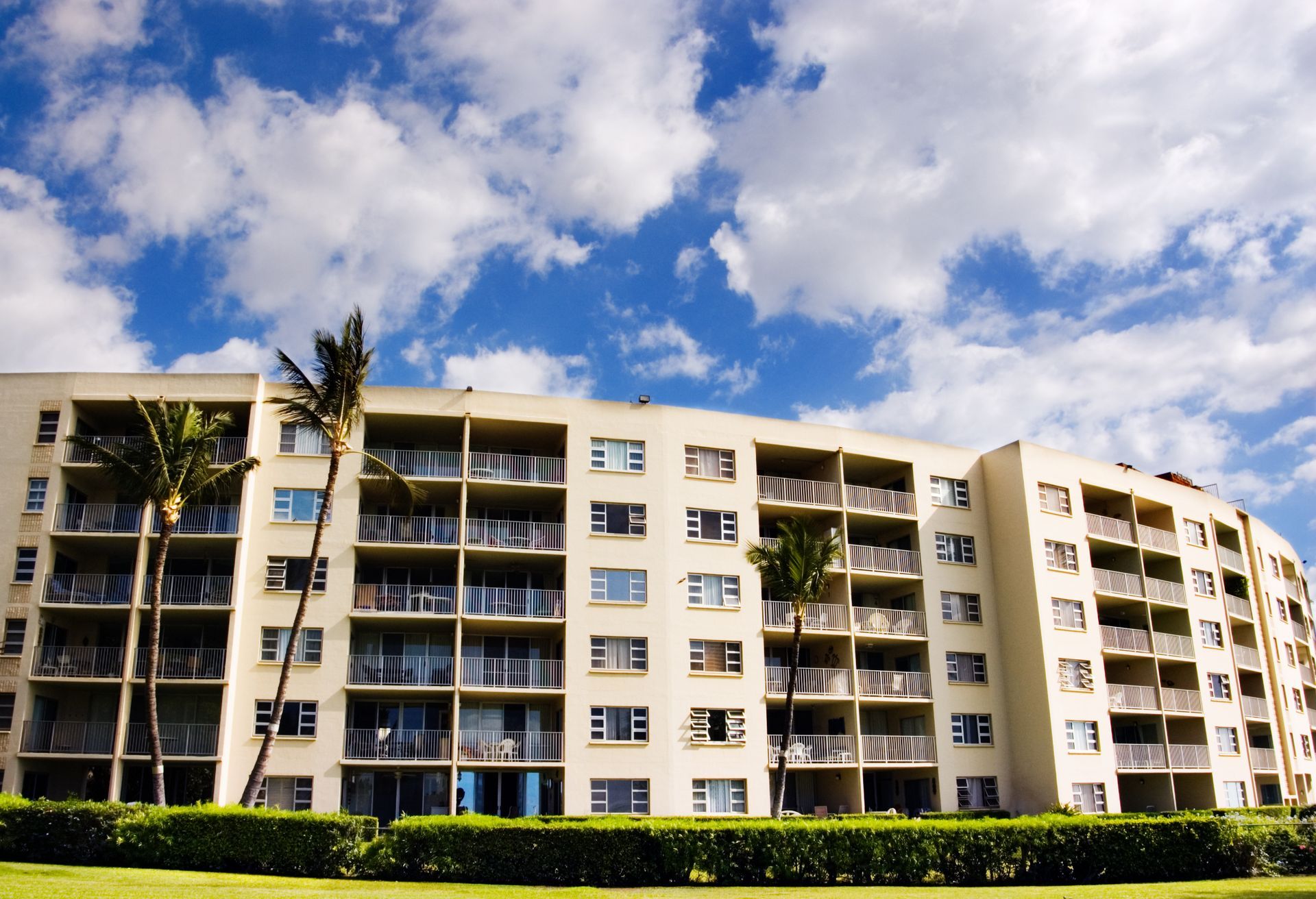 A large apartment building with palm trees in front of it