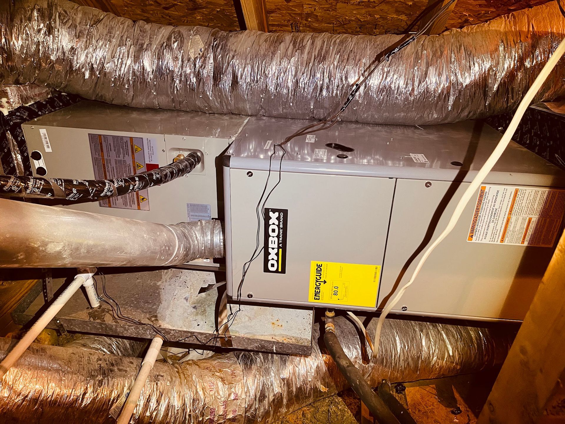 An air conditioner is installed in the attic of a house.