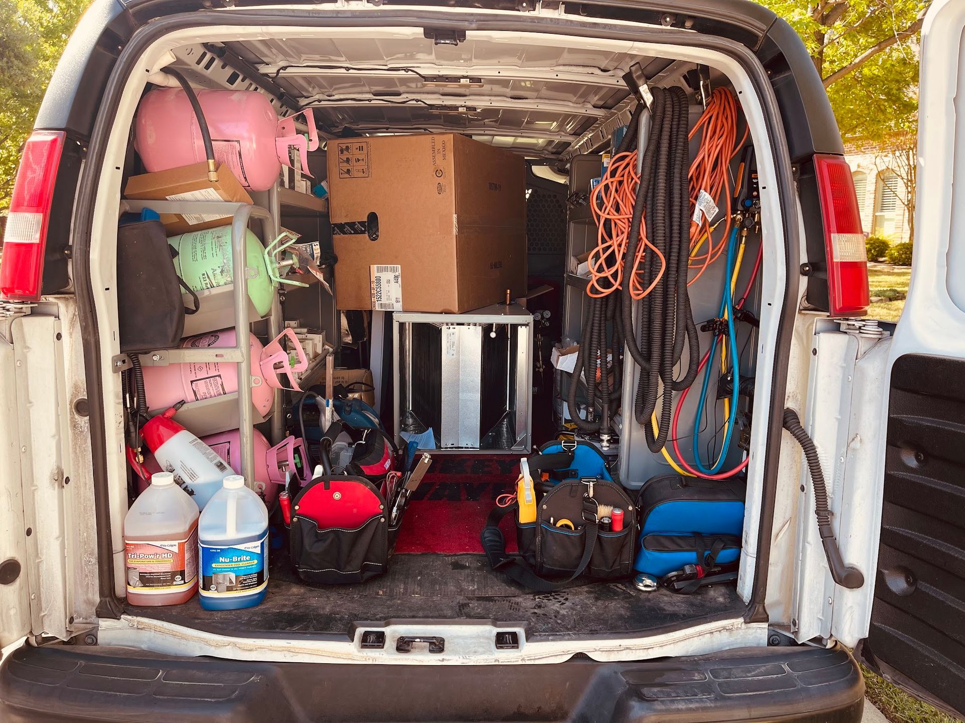 The back of a van is filled with tools and supplies.