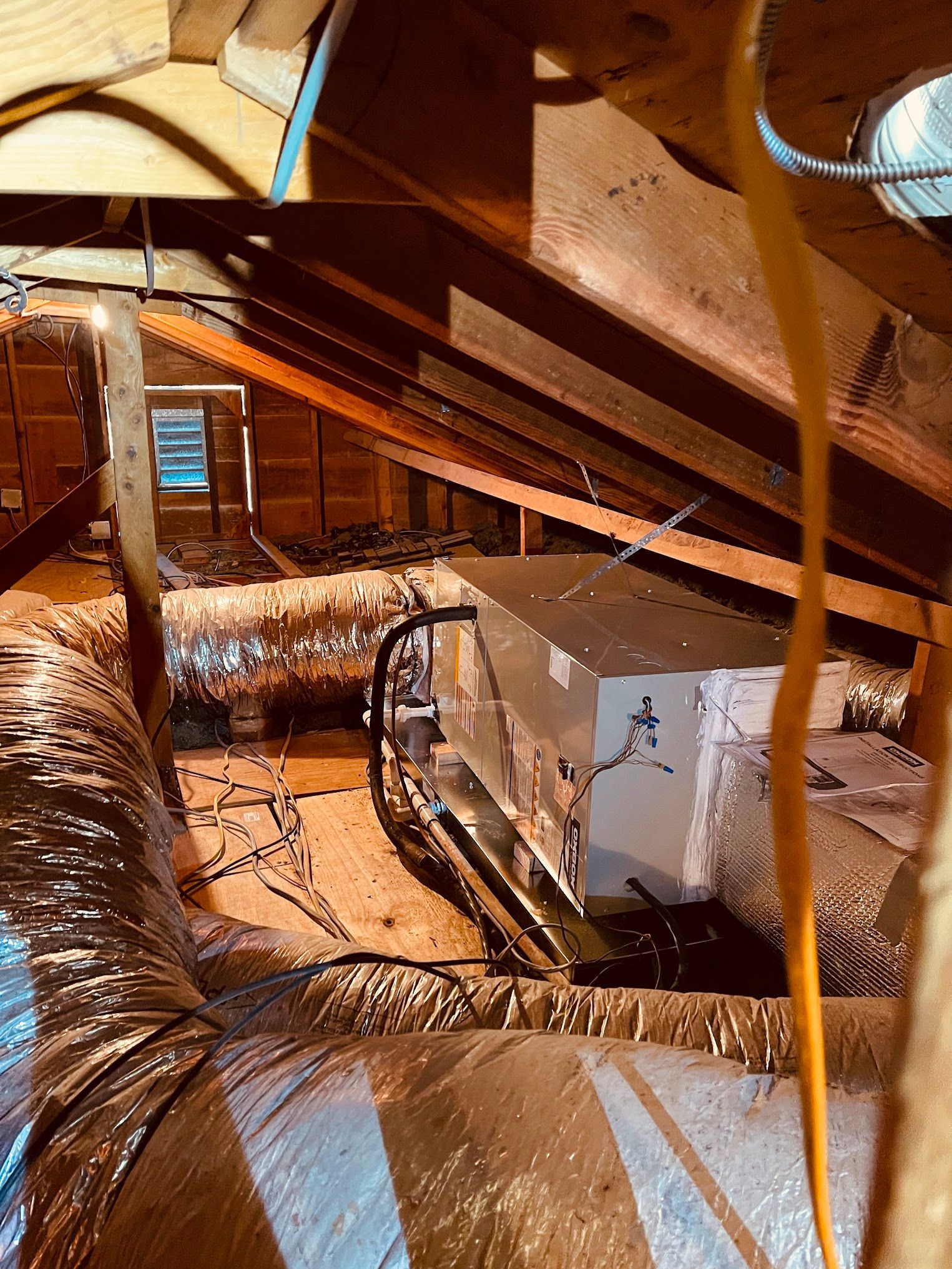 There is a box in the attic with a lot of wires coming out of it.