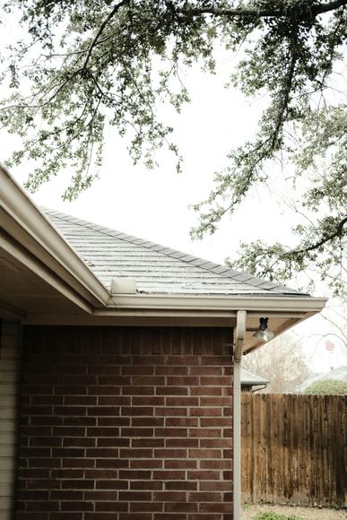 A brick house with a gutter on the side of it