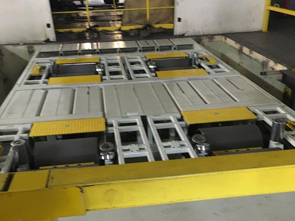 An industrial-looking machine with multiple conveyor belts and yellow safety markings.