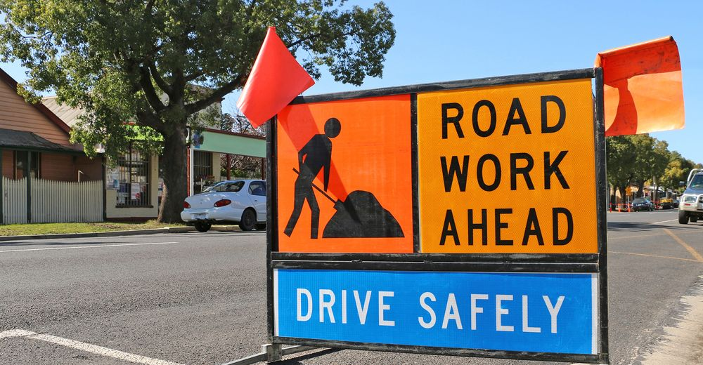 A large, colorful Snakes and Ladders game painted on the ground outdoors— Signvision In Dubbo, NSW