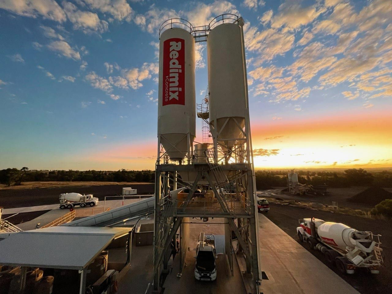 Concrete Plant with Two Silos and Redimix Logo at Sunset — Signvision In Dubbo, NSW