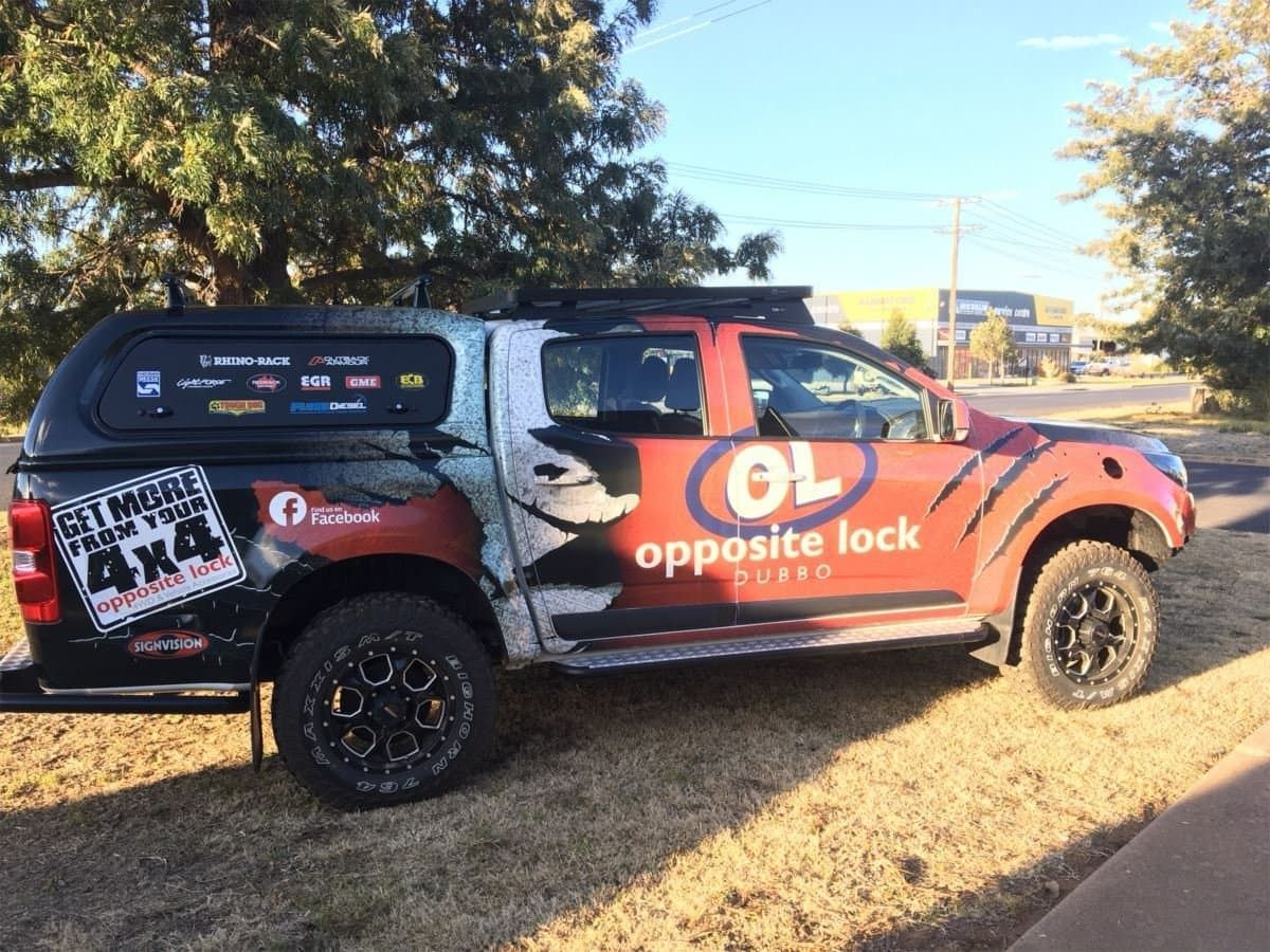 Red And Black Opposite Lock 4x4 Truck Parked On Grass — Signvision In Dubbo, NSW