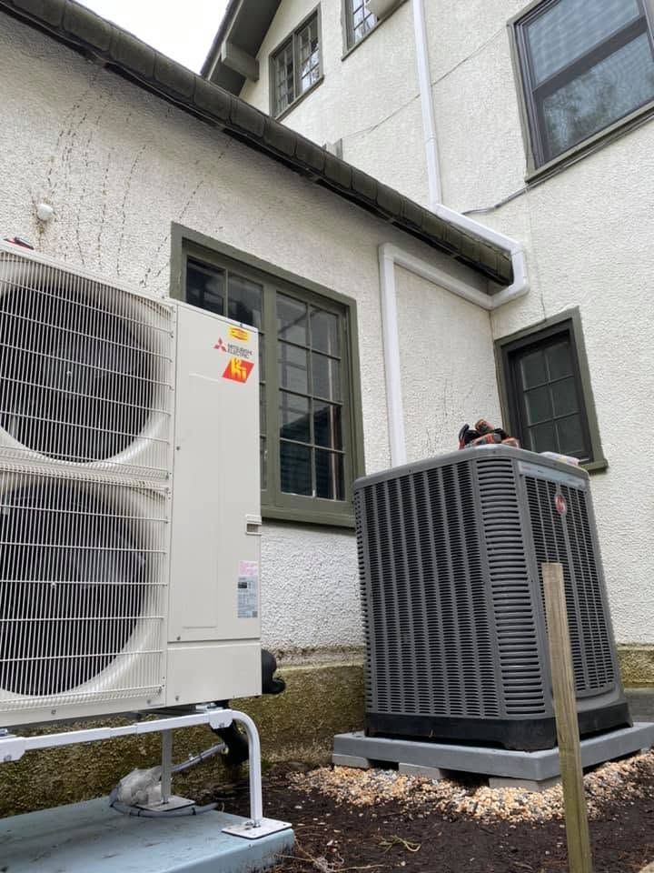 Outdoor HVAC units beside a white house, with one large condenser in the foreground. Outdoor HVAC units beside a white house, with one large condenser in the foreground.