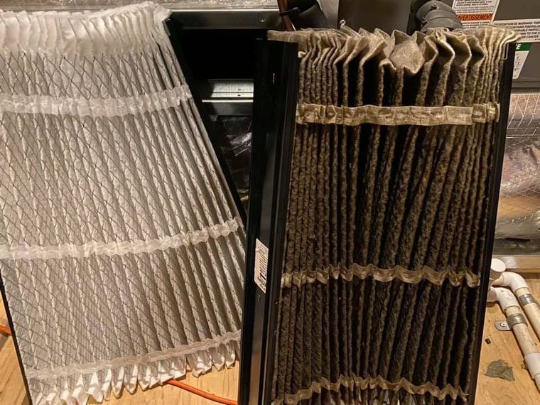 Two folded fabric samples, one light beige and one dark brown, draped over a black stand Two folded fabric samples, one light beige and one dark brown, draped over a black stand