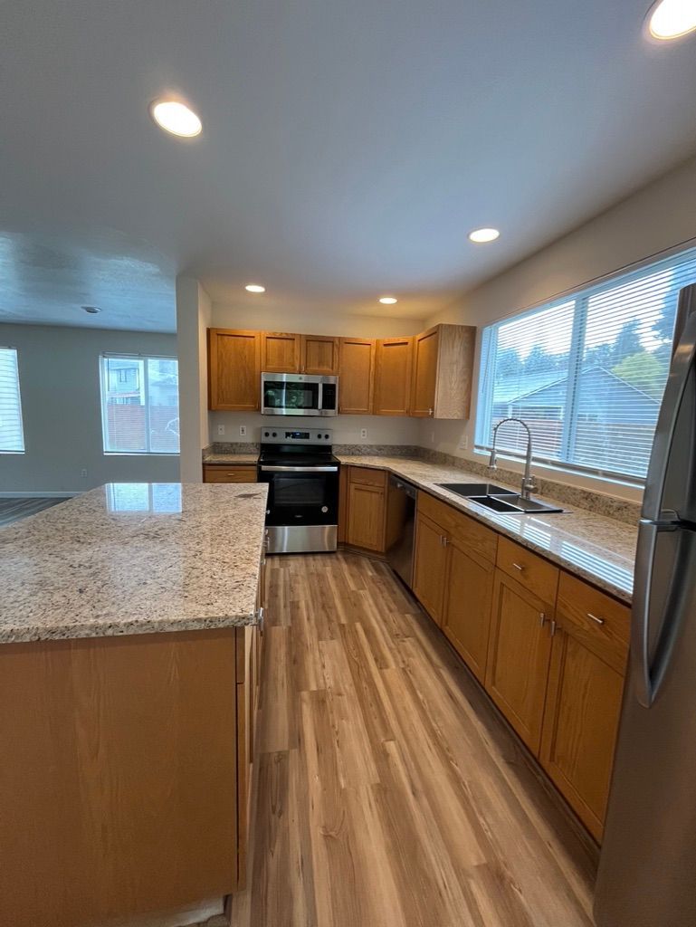 Kitchen with wood cabinets, granite countertops, and stainless steel appliances.