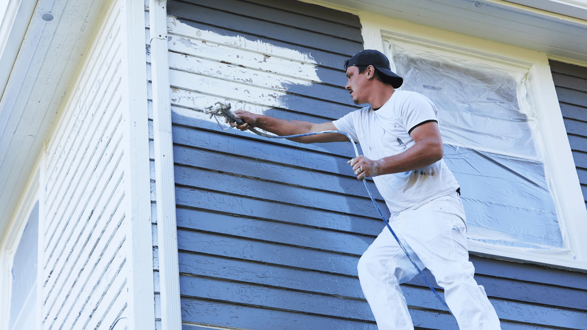 A man is painting the side of a house.