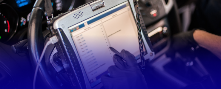 A person in black gloves using a tablet to diagnose a car's computer system inside the vehicle | AUTOPRO Oakville